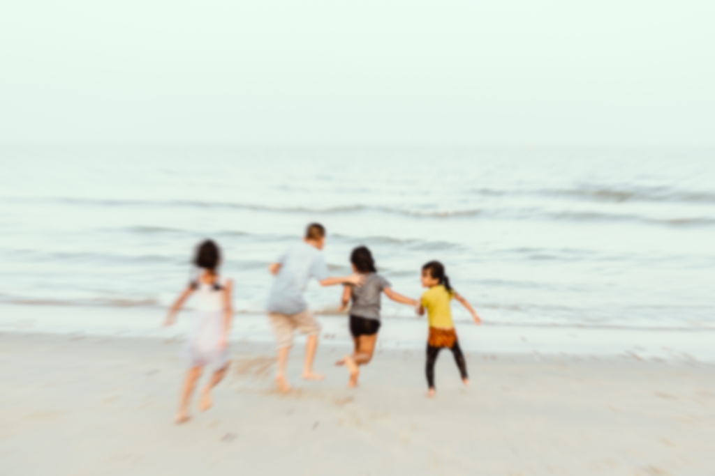 10 Tage Wetter Dänemark - Eine Gruppe von Menschen genießt einen verschwommenen Moment am Strand, was die flüchtige Schönheit der Natur und die Freude an gemeinsamen Erlebnissen einfängt.