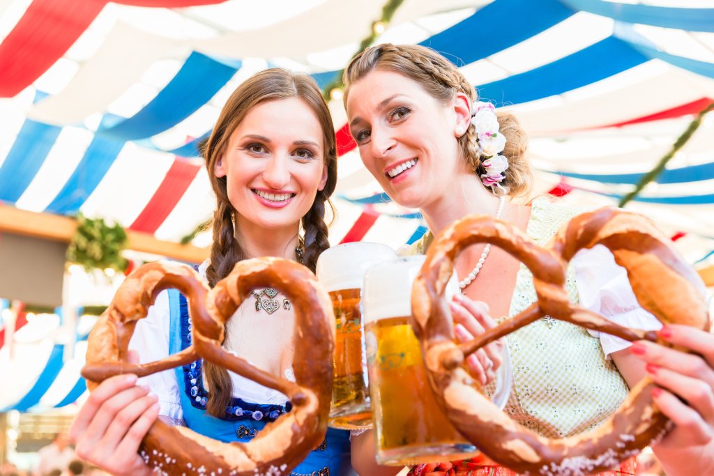 Wetter Dänemark 7-Tage – Zwei Frauen in Trachten halten Brezeln und Bier auf einem Volksfest.
