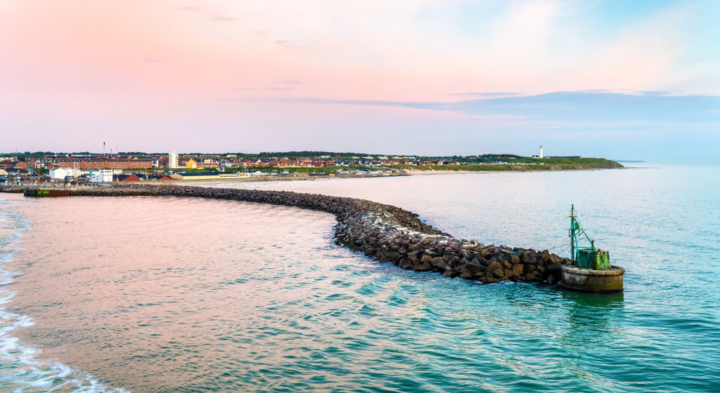 Abendstimmung in der Jammerbucht Dänemark Ferienhaus Jammerbucht - Sanfte Abenddämmerung über der Jammerbucht, mit einem Blick auf die schützende Wellenbrechermauer und den Leuchtturm am Horizont.