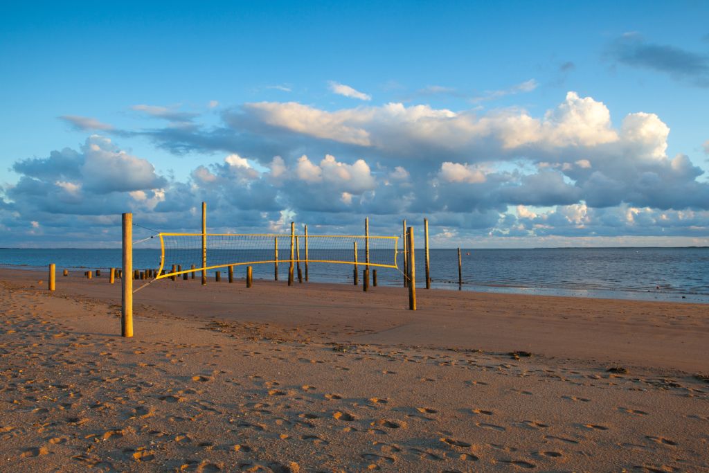 Freizeitspaß am Strand von Westjütland Dänemark Westjütland Ferienhaus - Ein leeres Volleyballfeld auf einem ruhigen Sandstrand in der Abendsonne, eingebettet in die malerische Küstenlandschaft Westjütlands nahe eines Ferienhauses.