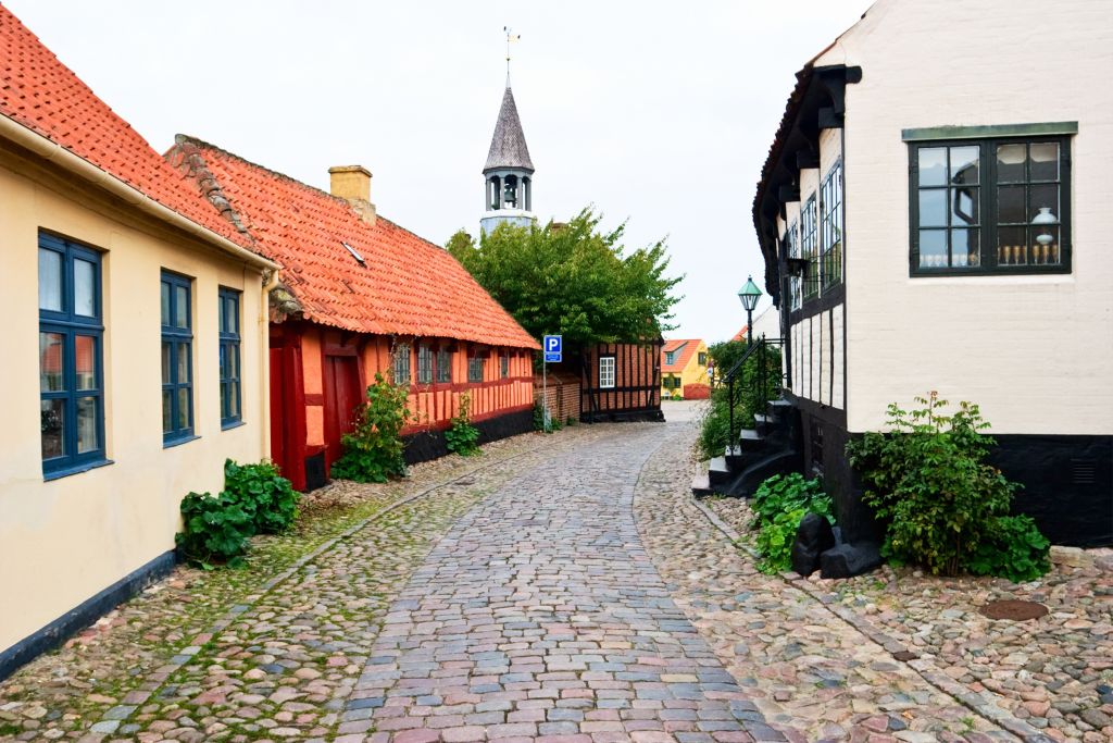 Ebeltoft Restaurant in einer malerischen Gasse mit Kopfsteinpflaster und traditionellen dänischen Häusern.