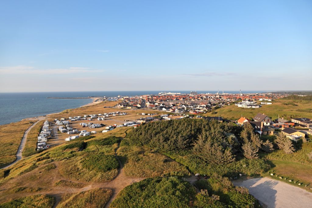 Ferienhaus Hirtshals mit Blick auf die malerische Küstenstadt und ihre Umgebung aus der Vogelperspektive an einem sonnigen Tag.
