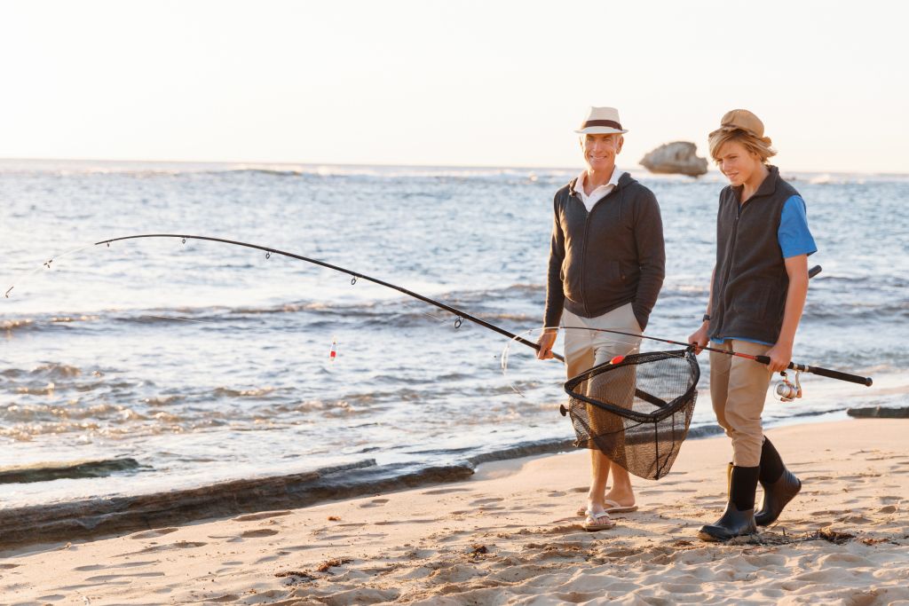 Ferienhaus Klegod - Ein Mann und ein Junge gehen am Strand angeln, ein Moment des Zusammenkommens und der Freizeit bei Klegod.