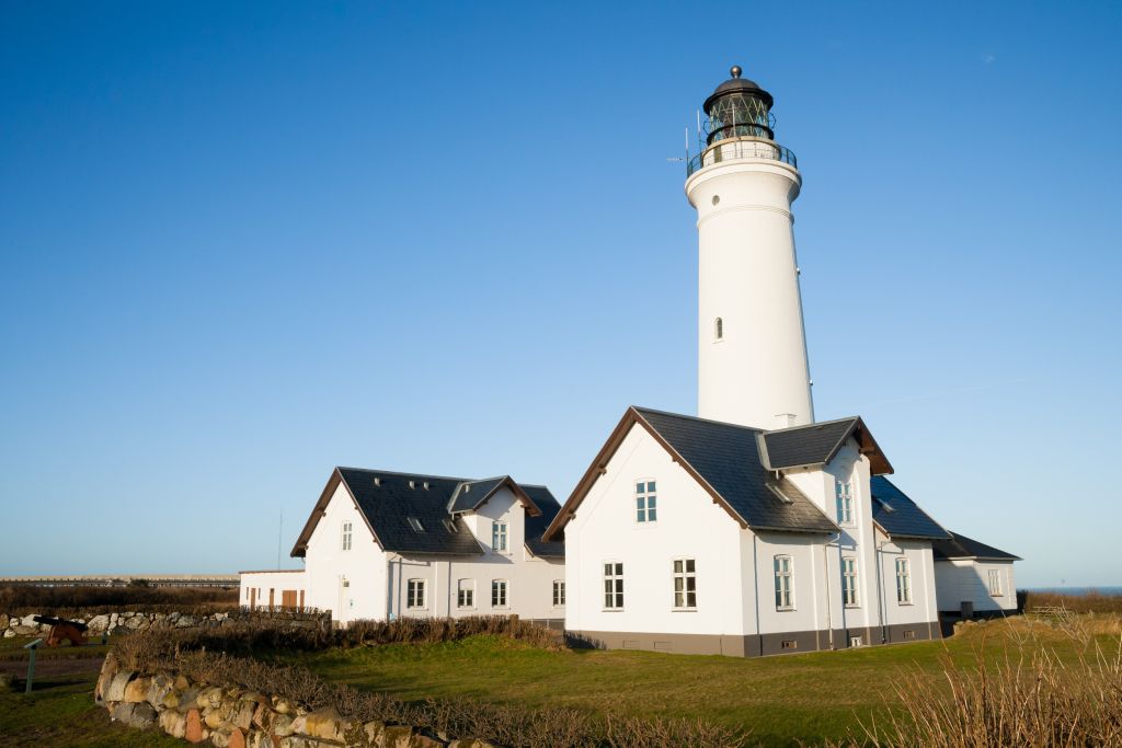 Hirtshals Wetter zeigt einen strahlend blauen Himmel über dem Leuchtturm und den umliegenden weißen Gebäuden, ein typisches Bild für einen klaren Tag in der Region.