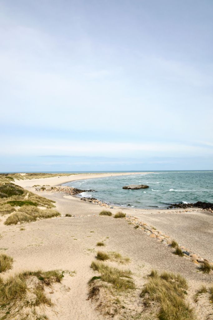 Skagen - Blick auf die windgepeitschten Dünen und die sanften Wellen an einem sonnigen Tag in Skagen, Dänemark.